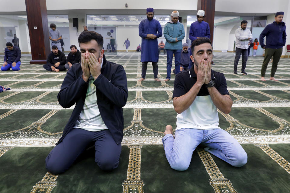 Brothers Samiullah Safi, left, and Abdul Wasi Safi pray during Friday prayers at the Al-Noor Society Mosque in Houston, on April 7, 2023. Abdul, who had suffered injuries while assisting the U.S. military in Afghanistan during the war, has recently arrived in Houston after being detained for months, but has no documentation allowing him to begin a normal life with his brother Samiullah. (AP Photo/Michael Wyke)