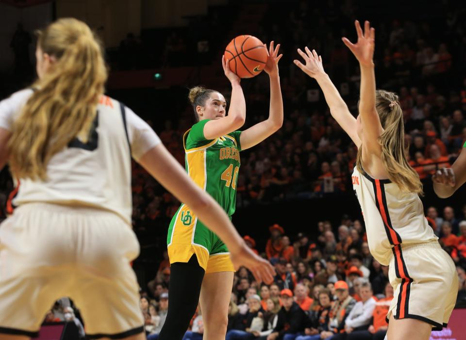 Oregon’s Grace VanSlooten, center, shoots over the Oregon State defense during the first half in Corvallis Sunday, Dec. 31, 2023.