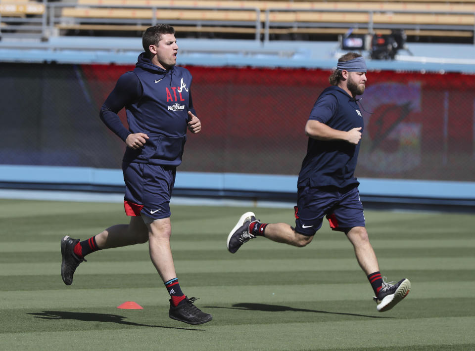 Braves third baseman Austin Riley, left, and pitcher A.J. Minter run sprints as they prepare to play the Dodgers in game 5 of the NLCS on Thursday, Oct. 21, 2021, in Los Angeles. "Curtis Compton / Curtis.Compton@ajc.com"/Atlanta Journal-Constitution via AP)/Atlanta Journal-Constitution via AP)inning of Game 5 of the baseball NL Championship Series, Thursday, Oct. 21, 2021, in Los Angeles. (Curtis Compton/Atlanta Journal-Constitution via AP)