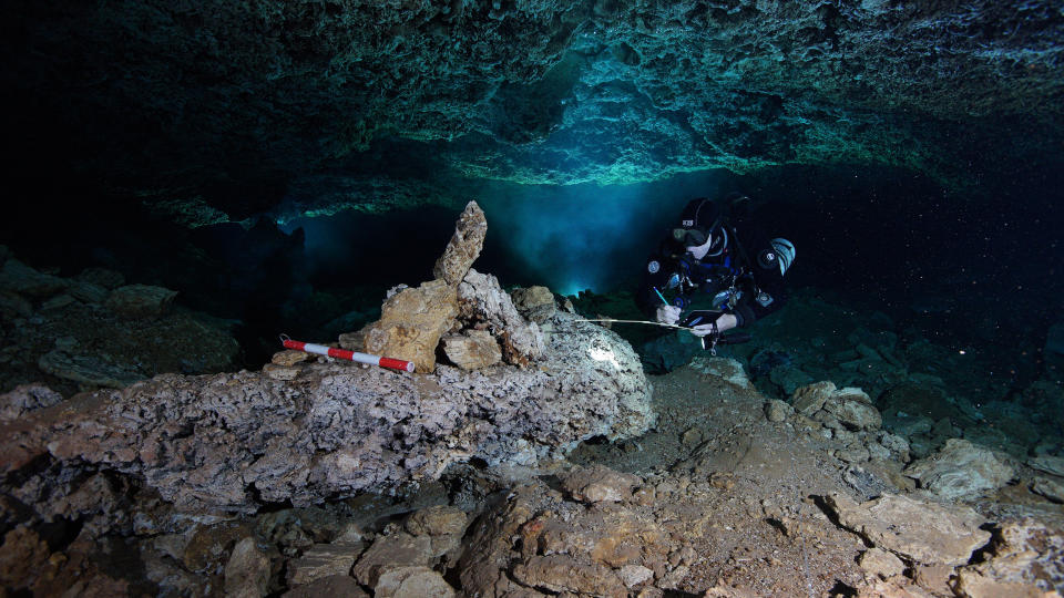 Image: A diver examines a navigational landmark in the now-flooded cave, left by ancient ochre miners more than 10,000 years ago. (CINDAQ.ORG)
