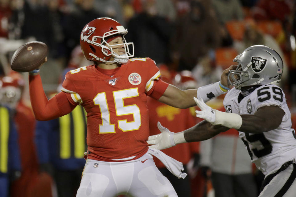 Kansas City Chiefs quarterback Patrick Mahomes (15) holds off Oakland Raiders linebacker Tahir Whitehead (59) during the second half of an NFL football game in Kansas City, Mo., Sunday, Dec. 1, 2019. (AP Photo/Charlie Riedel)