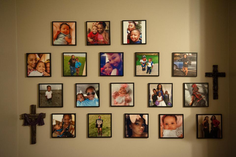 Three rows of photographs are mounted on a wall, with two crosses.