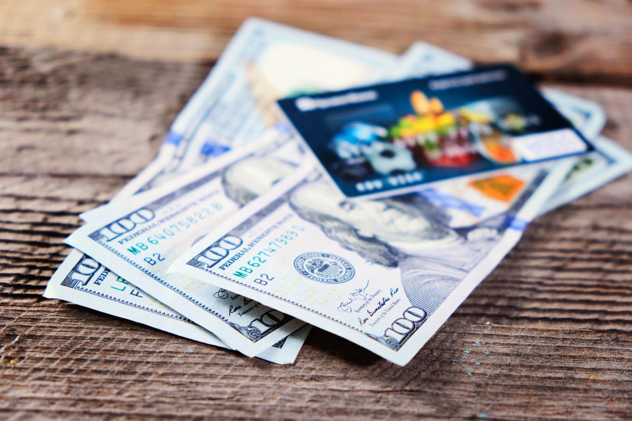 Photo of the bank credit cards and moneys on the wood table, selective focus. Closeup.