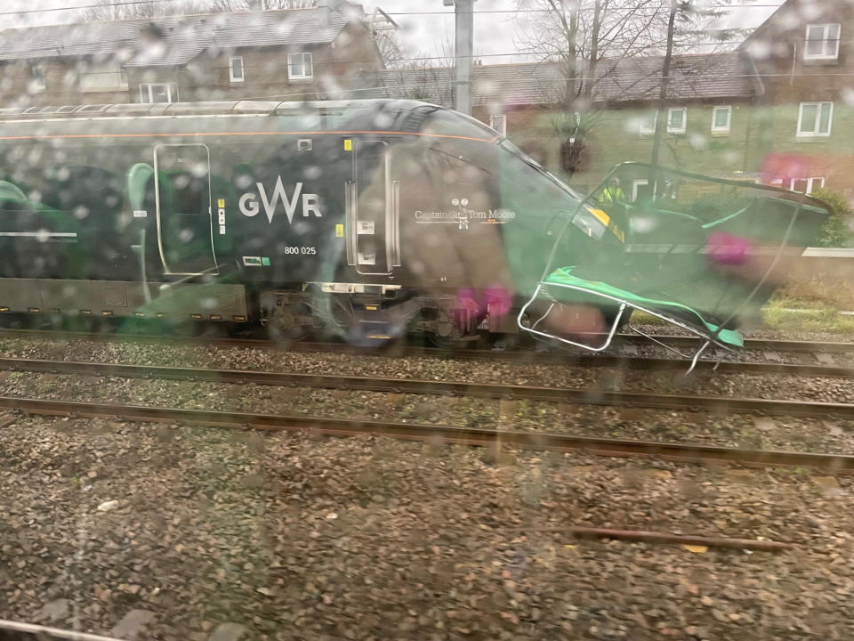 A train is seen stopped by a trampoline outside Cardiff as heavy winds hit the UK (SWNS)