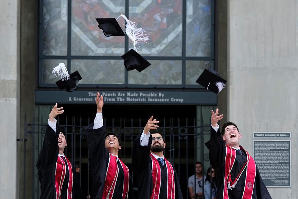 From left, Ohio State seniors Alec West, Jackson Guirnalda, Bassel Nassar and Zachary Horwitz toss up their caps while having their photos taken Tuesday by Fengning Liu in front of Ohio Stadium ahead of Sunday’s spring commencement ceremony there. The guys, who all received diplomas from Centerville High School in 2020, are excited to attend the commencement ceremony since their high school graduation was cancelled due to Covid-19.