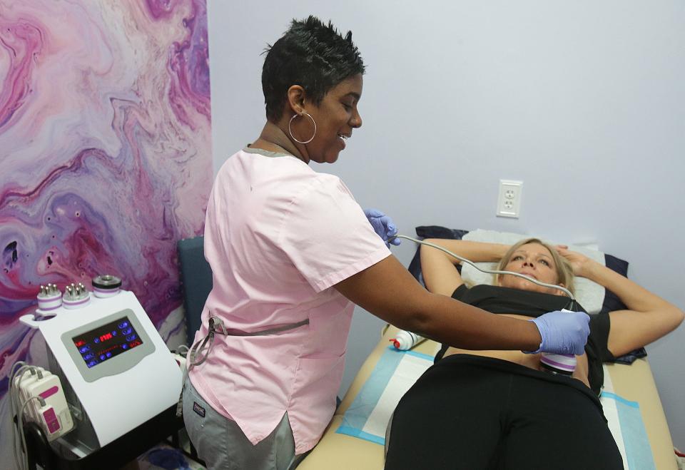 Nina Parr, owner of ParrTakeNCare demonstrates ultrasonic cavitation for weight loss on Melissa Tan at Premier Salon Suites in Jackson Township. Tan owns and operates Premier Salon Suites.