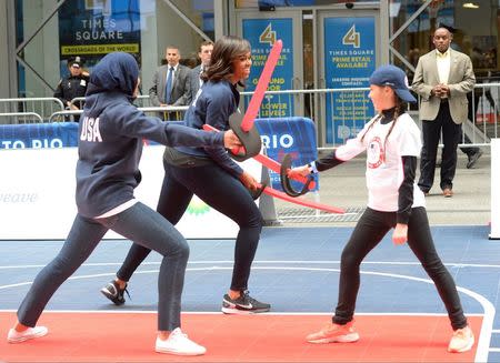 Apr 27, 2016; New York, NY, USA; First Lady Michelle Obama and fencer Ibithaj Muhammadin participate in a fencing demonstration during the U.S. Olympic Committee 100 day countdown event to the Rio 2016 Games at Times Square. Mandatory Credit: Robert Deutsch-USA TODAY Sports