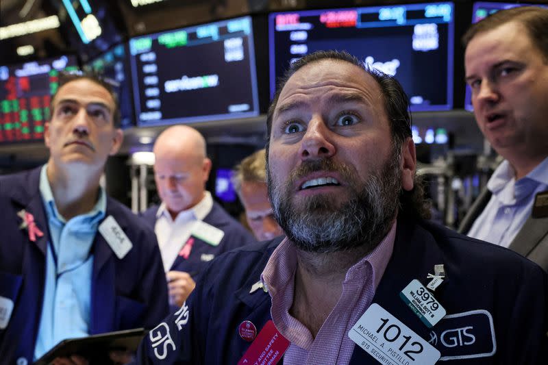 FILE PHOTO: Traders work on the floor of the NYSE in New York