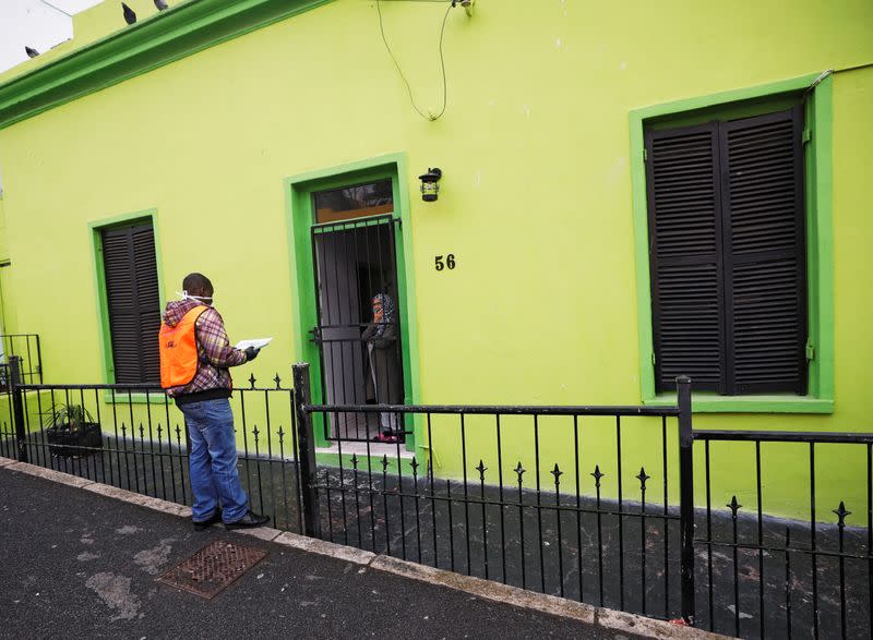 A health worker talks to residents as they conduct screening during the 21-day nationwide lockdown aimed at limiting the spread of coronavirus disease (COVID-19) in Bo Kaap, Cape Town