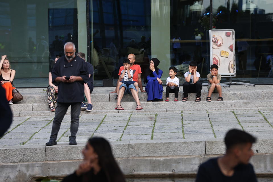 People evacuated from the Field's shopping center gather outside, in Orestad, Copenhagen, Denmark, Sunday, July 3, 2022, after reports of shots fired. (Olafur Steinar Gestsson /Ritzau Scanpix via AP)