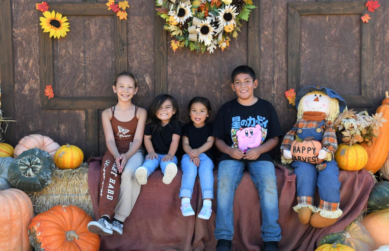 Children pose for photos on a decorative setup at the Triple F Farms Pumpkin Patch in Salinas, Calif.