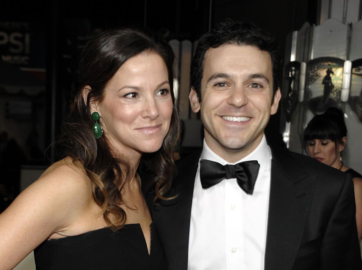 A woman and a man in formal attire arrive at a movie industry event.