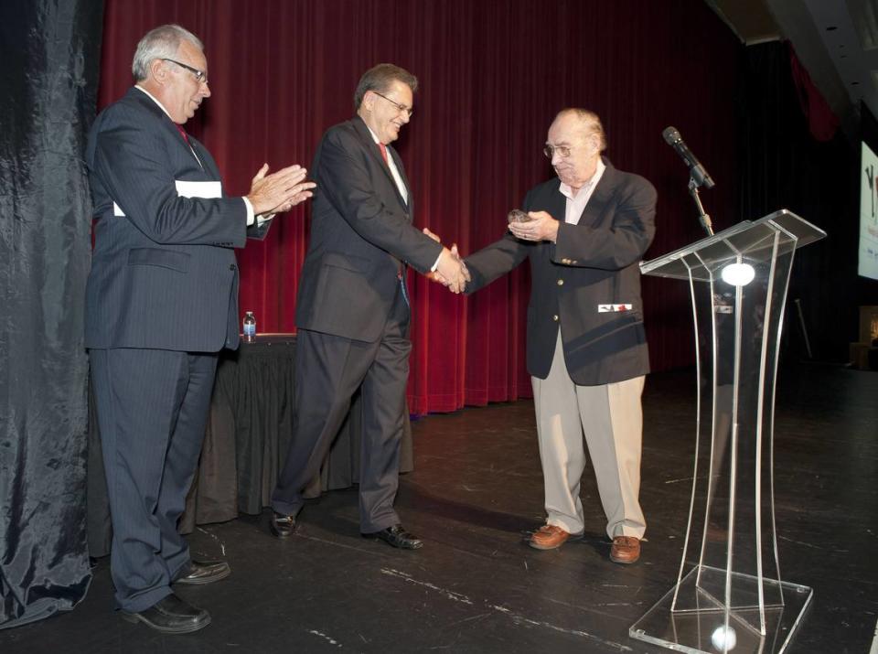 September 6, 2013 Joe Farruggio, left, and Bob Collins, right, present the 2013 American Red Cross South Mississippi Chapter Humanitarian Award to John McFarland, center, at the 6th Annual Moonlight and Magnolias.