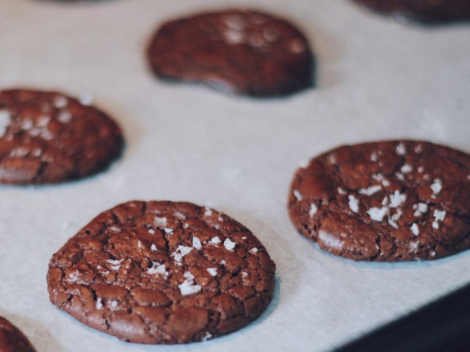 chocolate cookies on a baking sheet sprinkled with sea salt