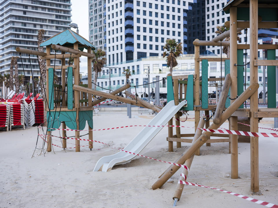This Thursday, March 19, 2020 photo shows playground at Tel Aviv's beachfront wrapped in tape to prevent public access. Israel has reported a steady increase in confirmed cases despite imposing strict travel bans and quarantine measures more than two weeks ago. Authorities recently ordered the closure of all non-essential businesses and encouraged people to work from home. (AP Photo/Oded Balilty)