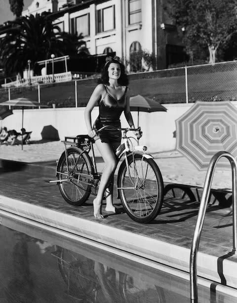 Rita Hayworth, Hollywood royalty, on a bicycle at the Beverly Hills Hotel in the Forties - Credit: This content is subject to copyright./Hulton Archive