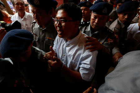 Detained Reuters journalist Wa Lone is escorted by police while arriving for a court hearing after a lunch break in Yangon, Myanmar February 21, 2018. REUTERS/Stringer
