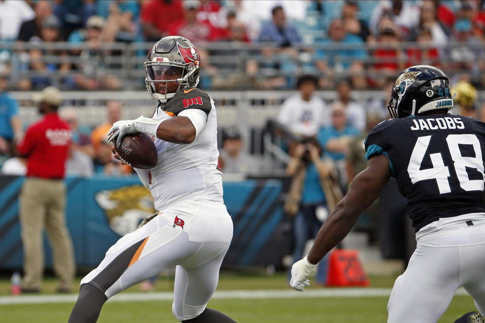 Tampa Bay Buccaneers quarterback Jameis Winston, left, looks for a receiver as he is pressured by Jacksonville Jaguars outside linebacker Leon Jacobs (48) during the first half of an NFL football game, Sunday, Dec. 1, 2019, in Jacksonville, Fla. (AP Photo/Stephen B. Morton)