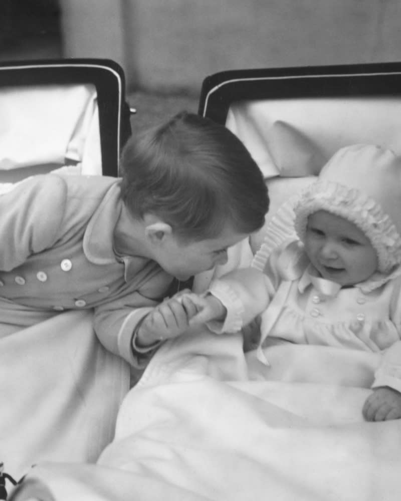 King Charles holds his baby sister's hand