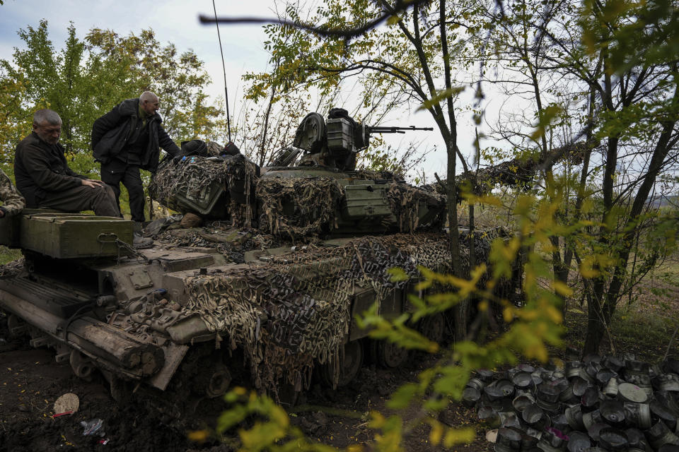 Ukrainian servicemen stand on Ukrainian Soviet-made T-64 tank, in Bakhmut, Ukraine, Sunday, Oct. 2, 2022. (AP Photo/Inna Varenytsia)