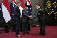 Indonesian Defense Minister Prabowo Subianto, center, gives souvenirs to Australian Deputy Prime Minister and Defense Minister Richard Marles, left, during their meeting in Jakarta, Indonesia, Friday, Feb. 23, 2024. (AP Photo/Achmad Ibrahim)