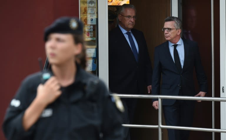 German Interior Minister Thomas de Maiziere (R) said in the age of social networks it was no longer police who controlled the "timing of the release of information, but everyone"