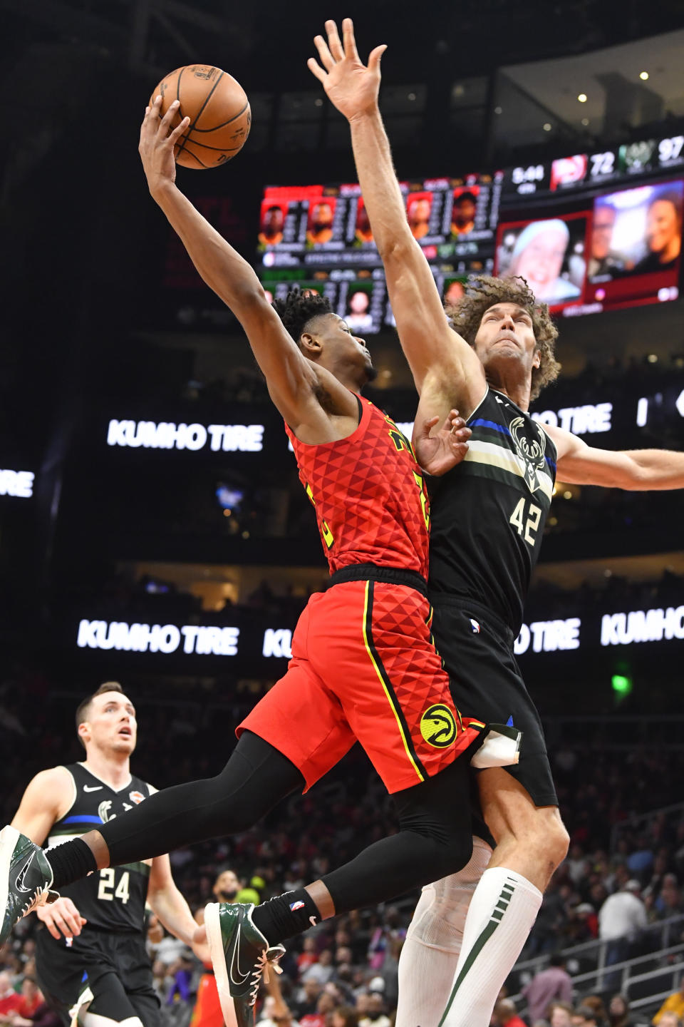 Atlanta Hawks forward Cam Reddish, center left, goes up to the basket as Milwaukee Bucks center Robin Lopez (42) defends during the second half of an NBA basketball game Friday, Dec. 27, 2019, in Atlanta. (AP Photo/John Amis)