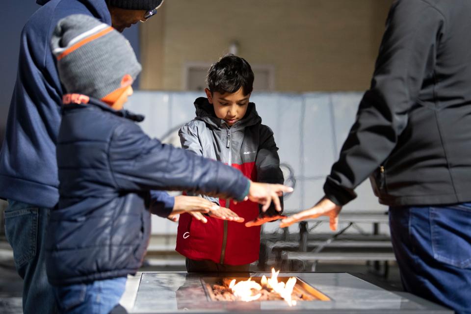 Samuel Jacob of Huntingdon Valley warms his hands by the firepit after iceskating at Flight on Ice Neshaminy Mall on Thursday, Dec. 29, 2022.