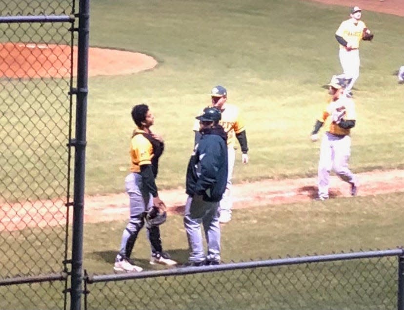 Matt Denham (center, with helmet on) speaks with catcher Justice Cooper during the 2021 baseball season.