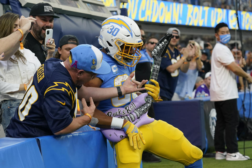 Los Angeles Chargers running back Austin Ekeler (30) celebrates with a fan after scoring a touchdown during the second half of an NFL football game against the Minnesota Vikings Sunday, Nov. 14, 2021, in Inglewood, Calif. (AP Photo/Gregory Bull )