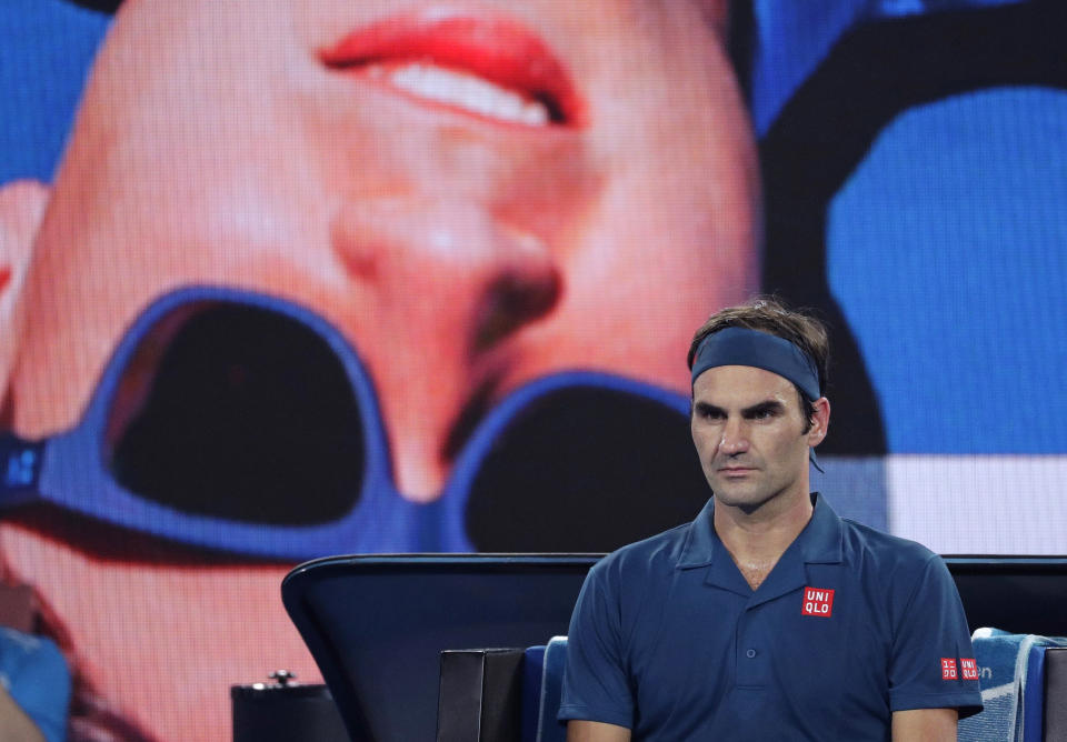 El suizo Roger Federer aguarda en su silla durante una pausa del partido contra el estadounidense Taylor Fritz por la tercera ronda del Abierto de Australia, el viernes 18 de enero de 2019. (AP Foto/Kin Cheung)