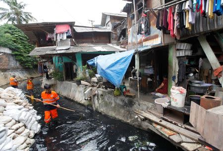 Jakarta government workers clean up a canal which runs into the Cilliwung river in Jakarta, Indonesia December 29, 2016. Picture taken December 29, 2016. REUTERS/Fatima El-Kareem