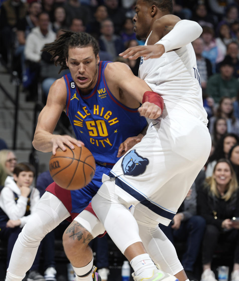 Denver Nuggets forward Aaron Gordon, left, drives past Memphis Grizzlies forward Xavier Tillman in the first half of an NBA basketball game Friday, March 3, 2023, in Denver. (AP Photo/David Zalubowski)