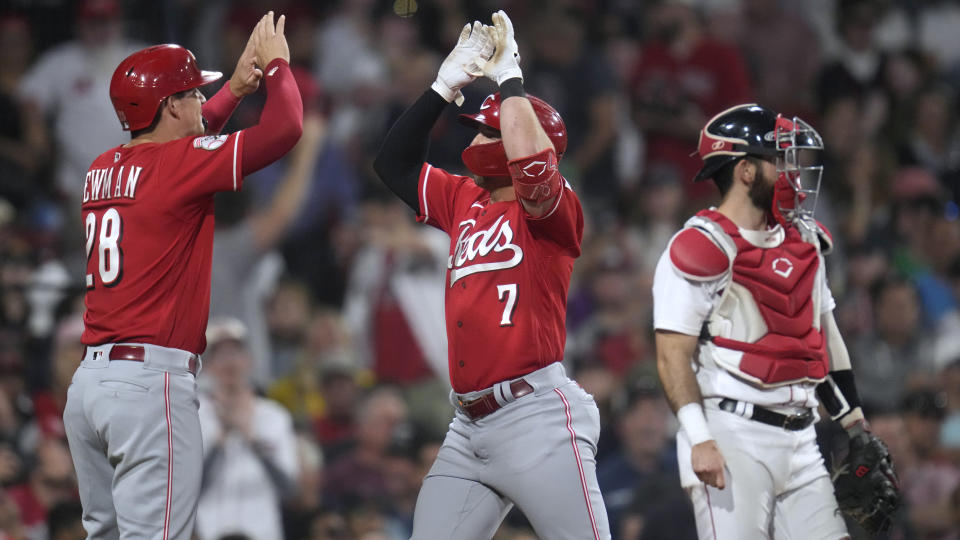 Cincinnati Reds' Spencer Steer (7) crosses home plate and celebrates with Kevin Newman (28) after his two-run home run against the Boston Red Sox during the seventh inning of a baseball game at Fenway Park, Wednesday, May 31, 2023, in Boston. At right is Red Sox catcher Connor Wong. (AP Photo/Charles Krupa)