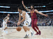 Denver Nuggets guard Facundo Campazzo, front left, drives past Cleveland Cavaliers guard Ricky Rubio in the second half of an NBA basketball game Monday, Oct. 25, 2021, in Denver. (AP Photo/David Zalubowski)