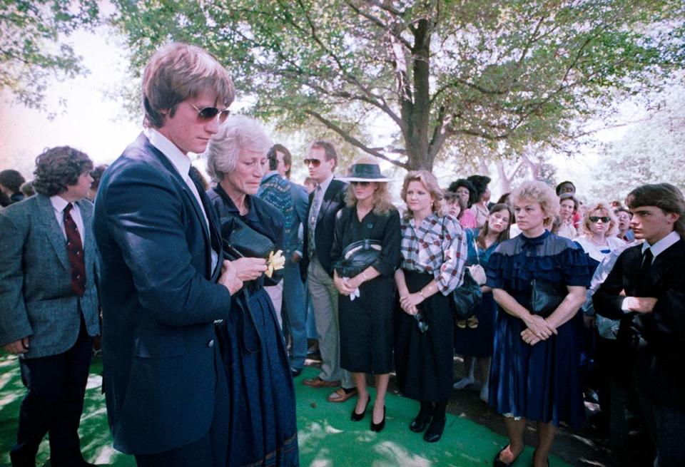 April 18, 1987: Doris Adkisson is seen being escorted to the gravesite by her son Kevin Von Erich at Grove Hill Memorial Park in Dallas during the funeral of her son, wrestler Mike Von Erich.