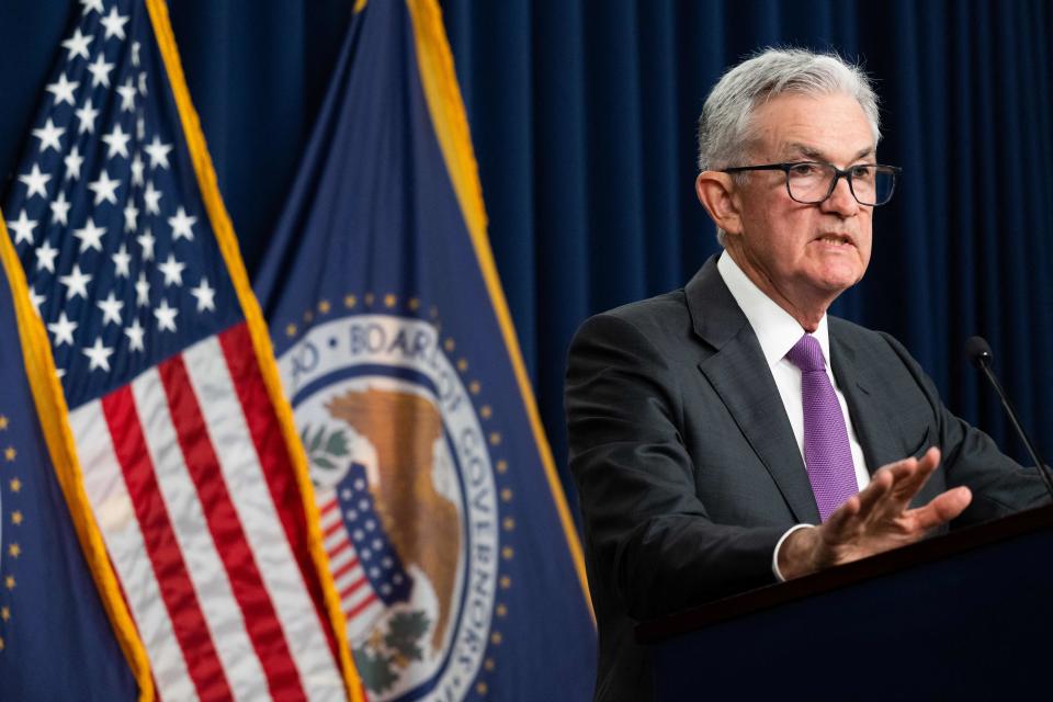 Federal Reserve Board Chairman Jerome Powell gestures at the podium at a news conference.