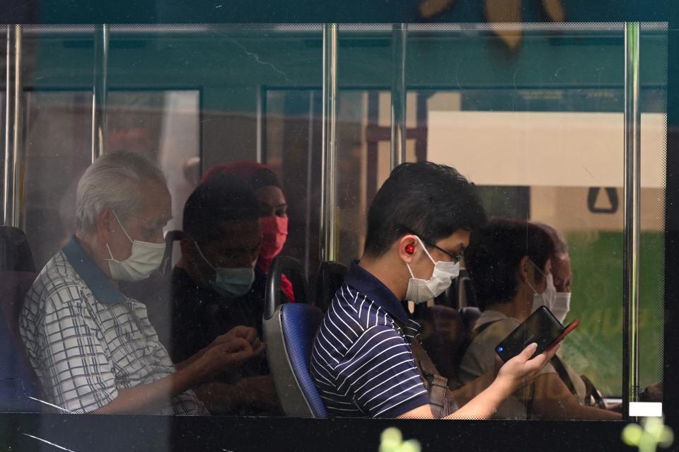 People wearing protective facemasks travel on a public bus in Singapore on September 14, 2021. (Photo by Roslan RAHMAN / AFP) (Photo by ROSLAN RAHMAN/AFP via Getty Images)