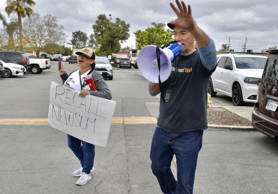 A few demonstrators protest outside AltaMed where California Gov. Gavin Newsom held press conference at the COVID-19 vaccination site in Santa Ana, Calif., on Thursday, March 25, 2020. California is expanding its vaccine eligibility to anyone 50 and over starting in April and anyone 16 and over on April 15, Gov. Newsom said Thursday. (Jeff Gritchen/The Orange County Register via AP)