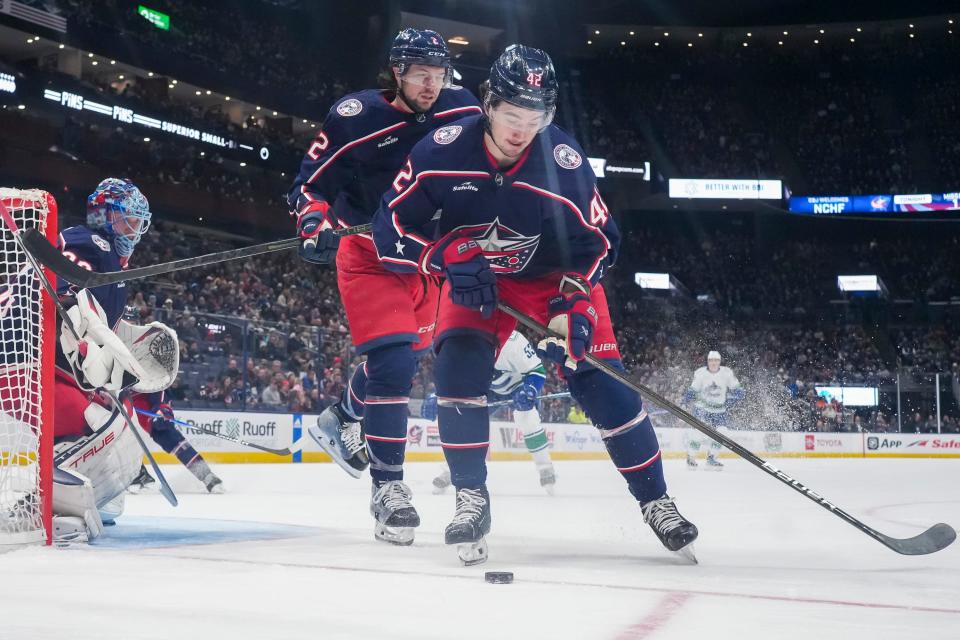 Jan 15, 2024; Columbus, Ohio, USA; Columbus Blue Jackets center Alexandre Texier (42) controls the puck in front of defenseman Andrew Peeke (2) during the second period of the NHL hockey game against the Vancouver Canucks at Nationwide Arena.