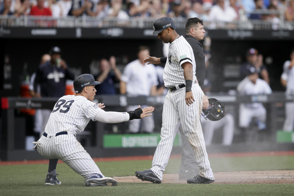 New York Yankees' Aaron Judge, left, and Aaron Hicks celebrate after scoring on a single by Gary Sanchez during the seventh inning of a baseball game against the Boston Red Sox in London, Sunday, June 30, 2019. (AP Photo/Tim Ireland)