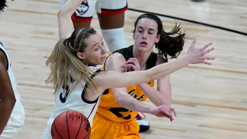 Iowa guard Caitlin Clark (22) passes the ball around UConn guard Paige Bueckers (5) during a college basketball game in the Sweet 16 round of the women's NCAA Tournament at the Alamodome in San Antonio, Saturday, March 27, 2021.