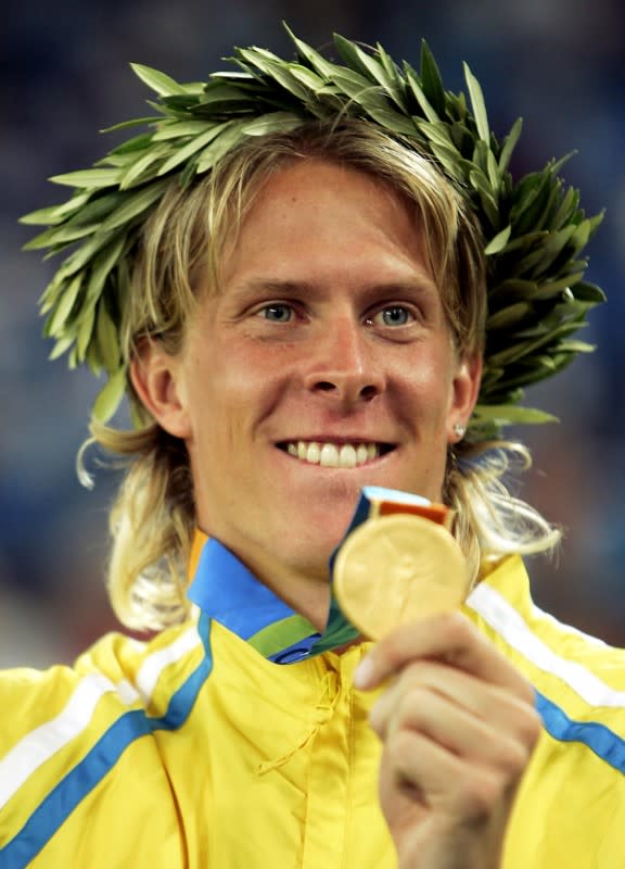 FILE PHOTO: Sweden's Olsson shows his gold medal for the men's triple jump at the Athens 2004 Olympic Games.