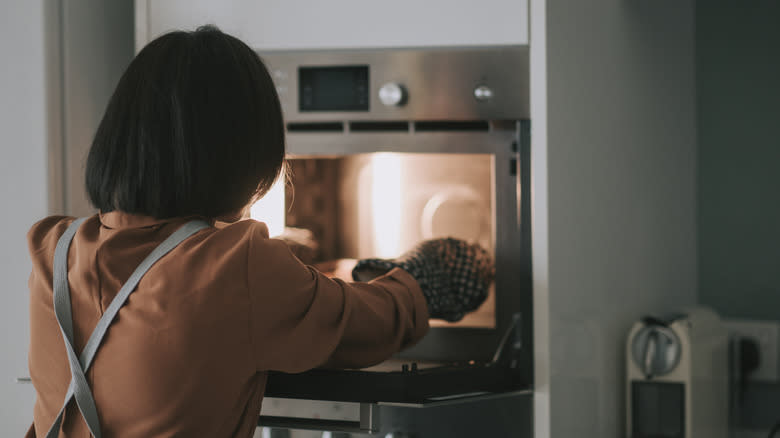 Person putting pan in oven