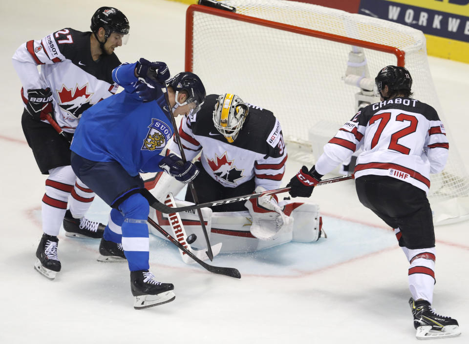 Canada's goaltender Matt Murray, 2nd right, and is teammates Thomas Chabot, right, and Shea Theodore, left, make a save against Finland's Jere Sallinen, 2nd left, during the Ice Hockey World Championships group A match between Finland and Canada at the Steel Arena in Kosice, Slovakia, Friday, May 10, 2019. (AP Photo/Petr David Josek)