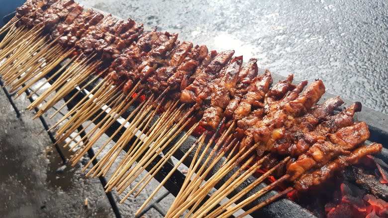 Row of grilling chicken satay