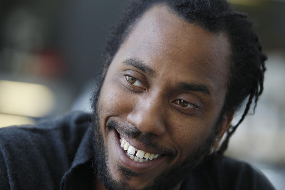 In this photo taken, Friday, April 6, 2012, artist Rashid Johnson smiles during an interview before his first solo exhibition at the Museum of Contemporary Art in Chicago. In the last year, the Chicago native whose works made from everyday objects explore his own life story as well as larger issues of black identity, has garnered high-profile attention and awards from the art world. (AP Photo/M. Spencer Green)