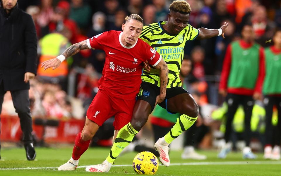 Bukayo Saka of Arsenal tangles with Konstantinos Tsimikas of Liverpool during the Premier League match between Liverpool FC and Arsenal FC at Anfield