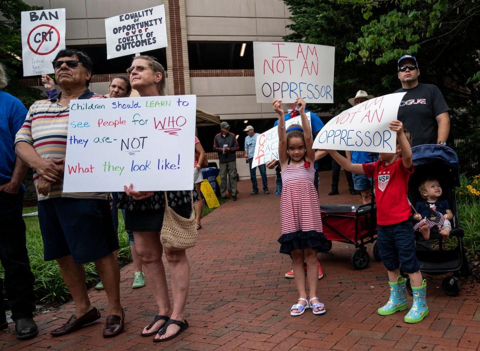 People hold up signs during a rally against critical race theory in Leesburg, Va., on June 12, 2021. <a href="https://www.gettyimages.com/detail/news-photo/people-hold-up-signs-during-a-rally-against-critical-race-news-photo/1233449643?phrase=anti%20CRT%20protests&adppopup=true" rel="nofollow noopener" target="_blank" data-ylk="slk:Andrew Caballero-Reynolds/AFP via Getty Images;elm:context_link;itc:0;sec:content-canvas" class="link ">Andrew Caballero-Reynolds/AFP via Getty Images</a>