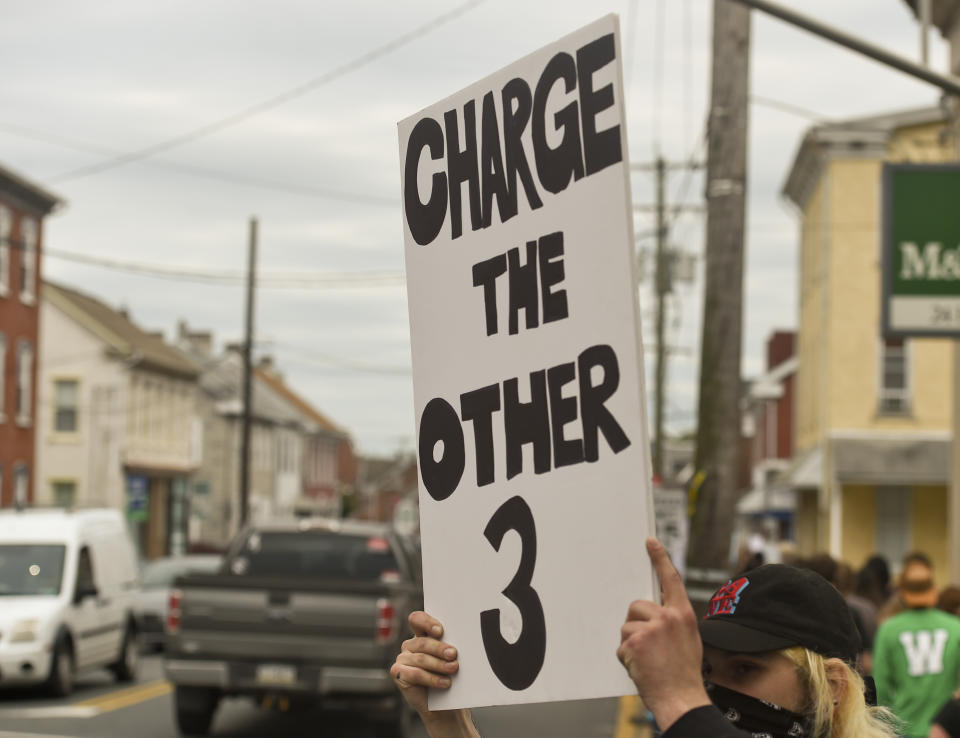 <i>In Boyertown, Pennsylvania, a protester holds a sign that says "Charge the other 3," referring to the other three police officers present when their colleague kneeled on George Floyd's neck and killed him. The former officers have <a href="https://www.huffpost.com/entry/3-cops-charged-george-floyd-death_n_5ed15c7cc5b63f2b5793fa50" target="_blank" rel="noopener noreferrer">since been charged</a> with aiding and abetting.</i>